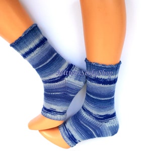 A pair of blue and white striped hand knit yoga socks with heel  with a light blue and white color gradient. The socks are made of a soft, comfortable sock yarn and are perfect for everyday wear. The socks are on a pair of mannequin feet.
