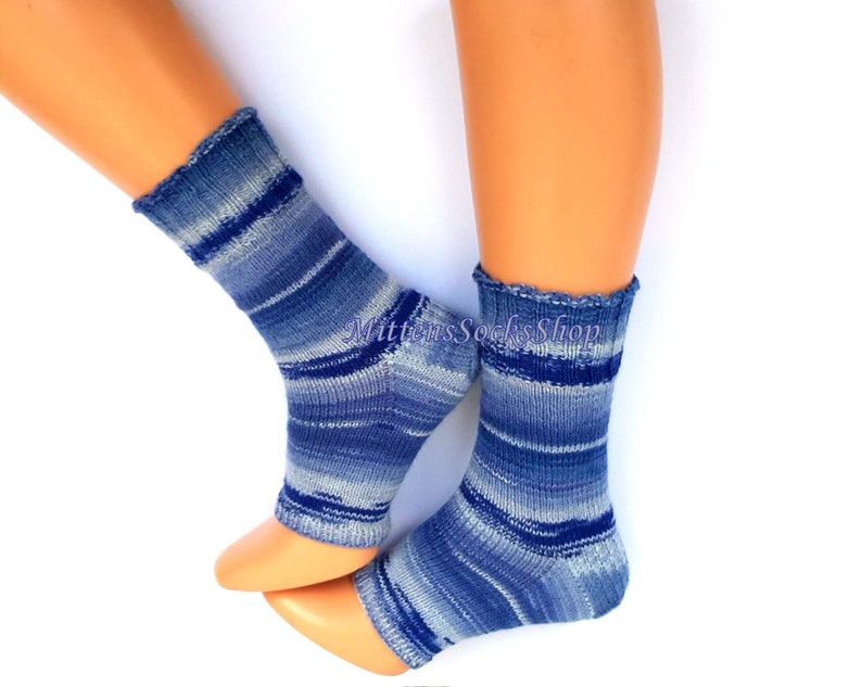 A pair of blue and white striped hand knit yoga socks with heel  with a light blue and white color gradient. The socks are made of a soft, comfortable sock yarn and are perfect for everyday wear. The socks are on a pair of mannequin feet.