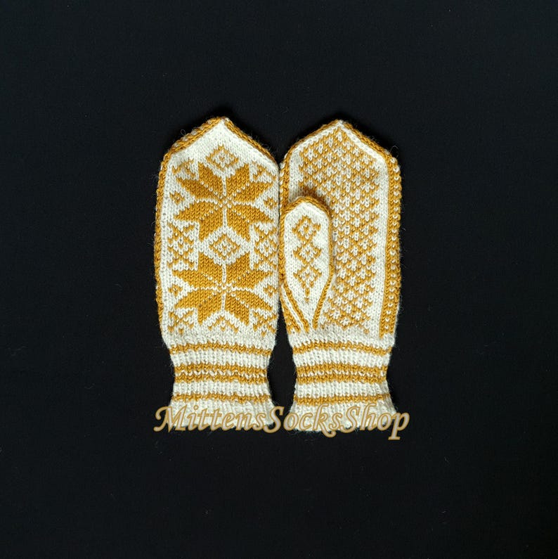 May include: A pair of white knitted mittens with a yellow snowflake pattern. The mittens have a ribbed cuff and are made of a soft, warm yarn.