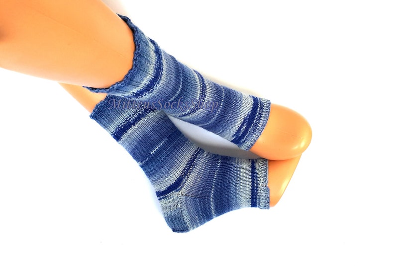 A pair of blue and white striped hand knit yoga socks with heel  with a light blue and white color gradient. The socks are made of a soft, comfortable sock yarn and are perfect for everyday wear.