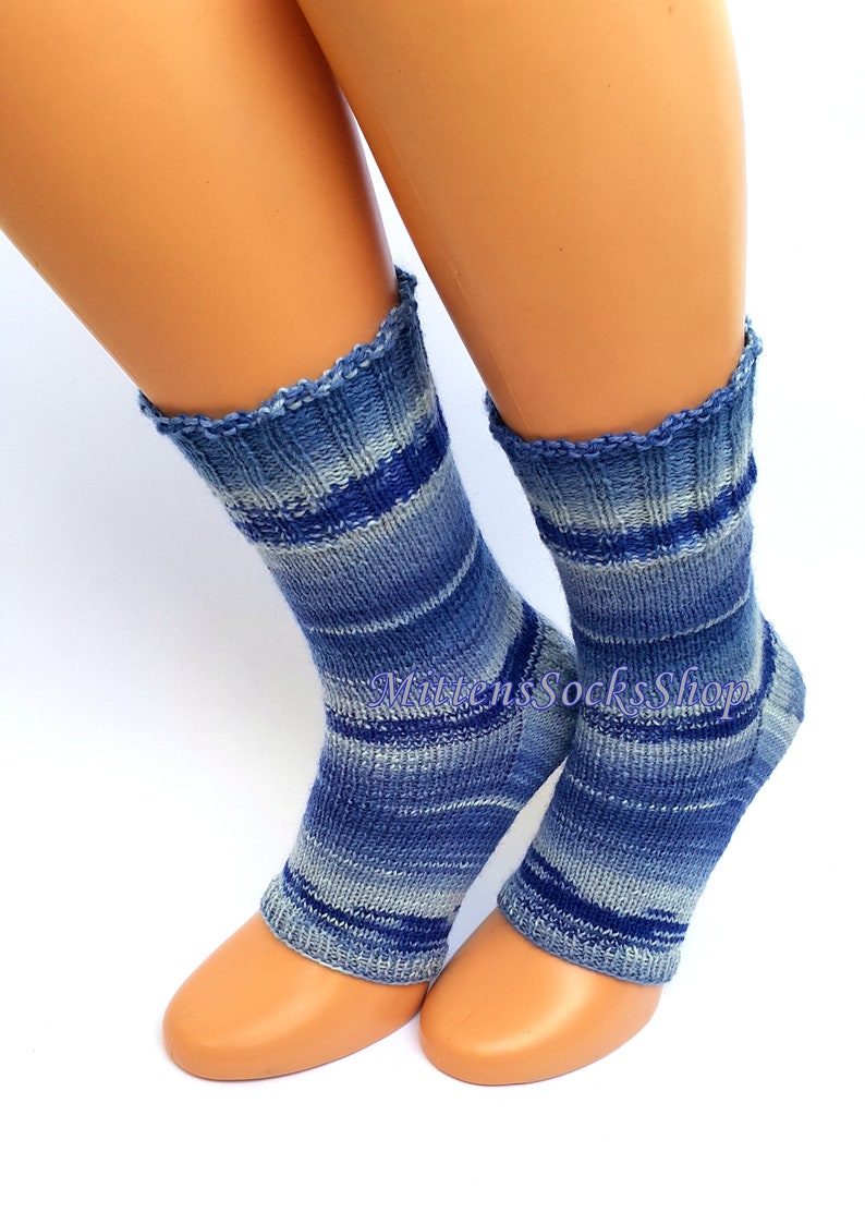 A pair of blue and white striped hand knit yoga socks with heel  with a light blue and white color gradient. The socks are made of a soft, comfortable sock yarn and are perfect for everyday wear. The socks are on a pair of mannequin feet. The socks are displayed on a white background.