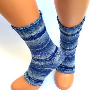 A pair of blue and white striped hand knit yoga socks with heel  with a light blue and white color gradient. The socks are made of a soft, comfortable sock yarn and are perfect for everyday wear. The socks are on a pair of mannequin feet.