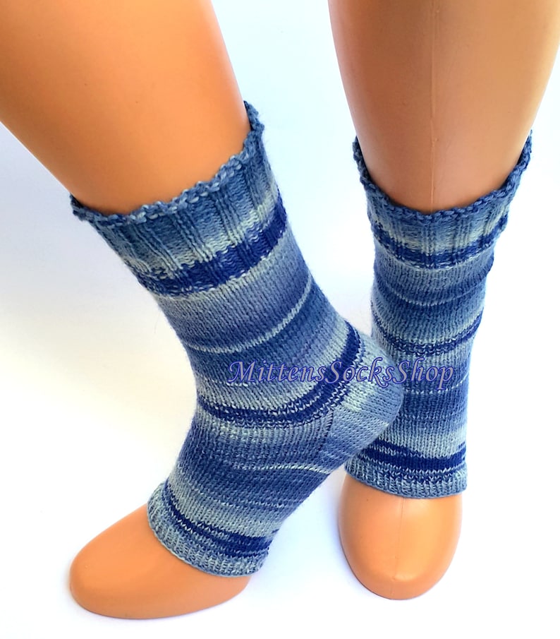 A pair of blue and white striped hand knit yoga socks with heel  with a light blue and white color gradient. The socks are made of a soft, comfortable sock yarn and are perfect for everyday wear. The socks are on a pair of mannequin feet.