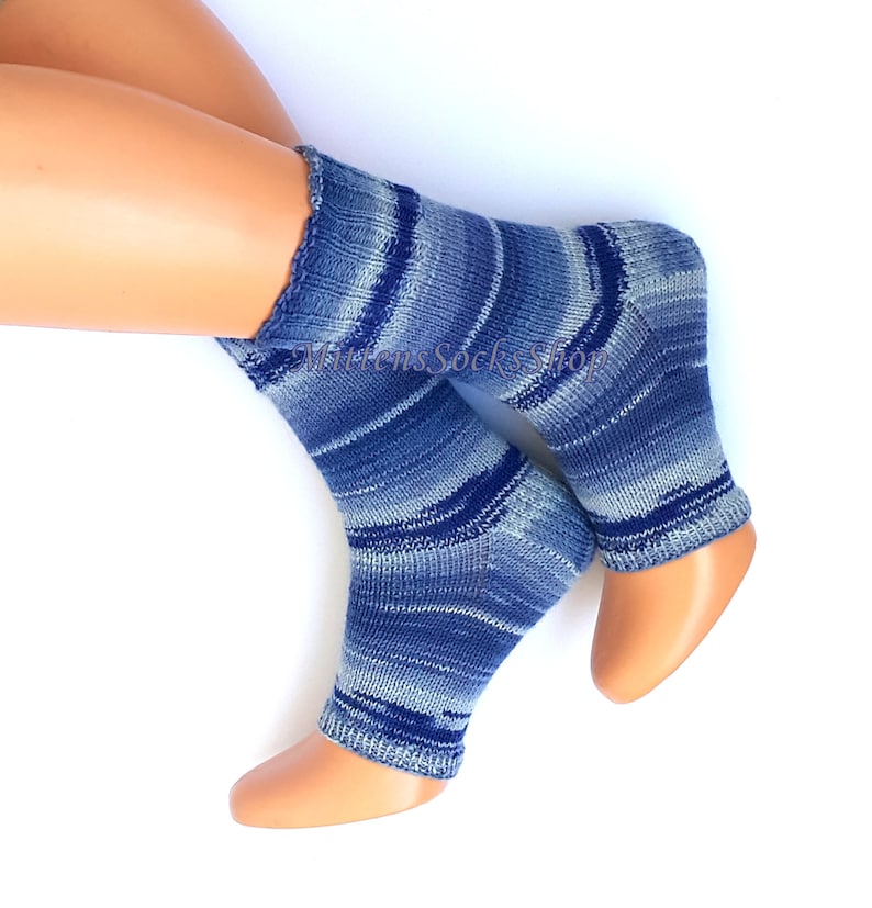 A pair of blue and white striped hand knit yoga socks with heel  with a light blue and white color gradient. The socks are made of a soft, comfortable sock yarn and are perfect for everyday wear. The socks are on a pair of mannequin feet.