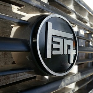 Insignia de parrilla TEQ 80 Cruiser/LX450