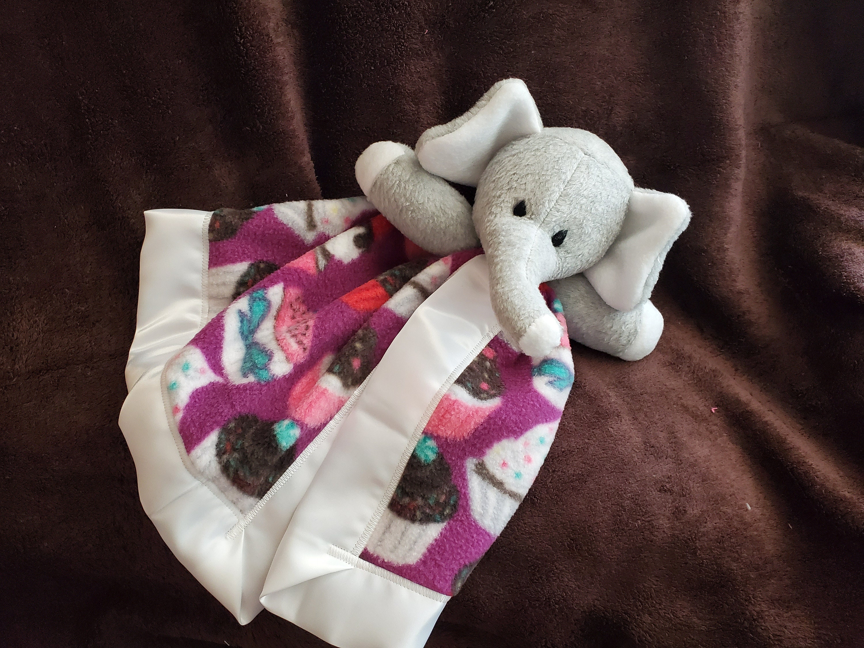 Mini Elephant Blanket Buddy Who is Oh so Cuddly With a Cupcake Design on a Purple Background and