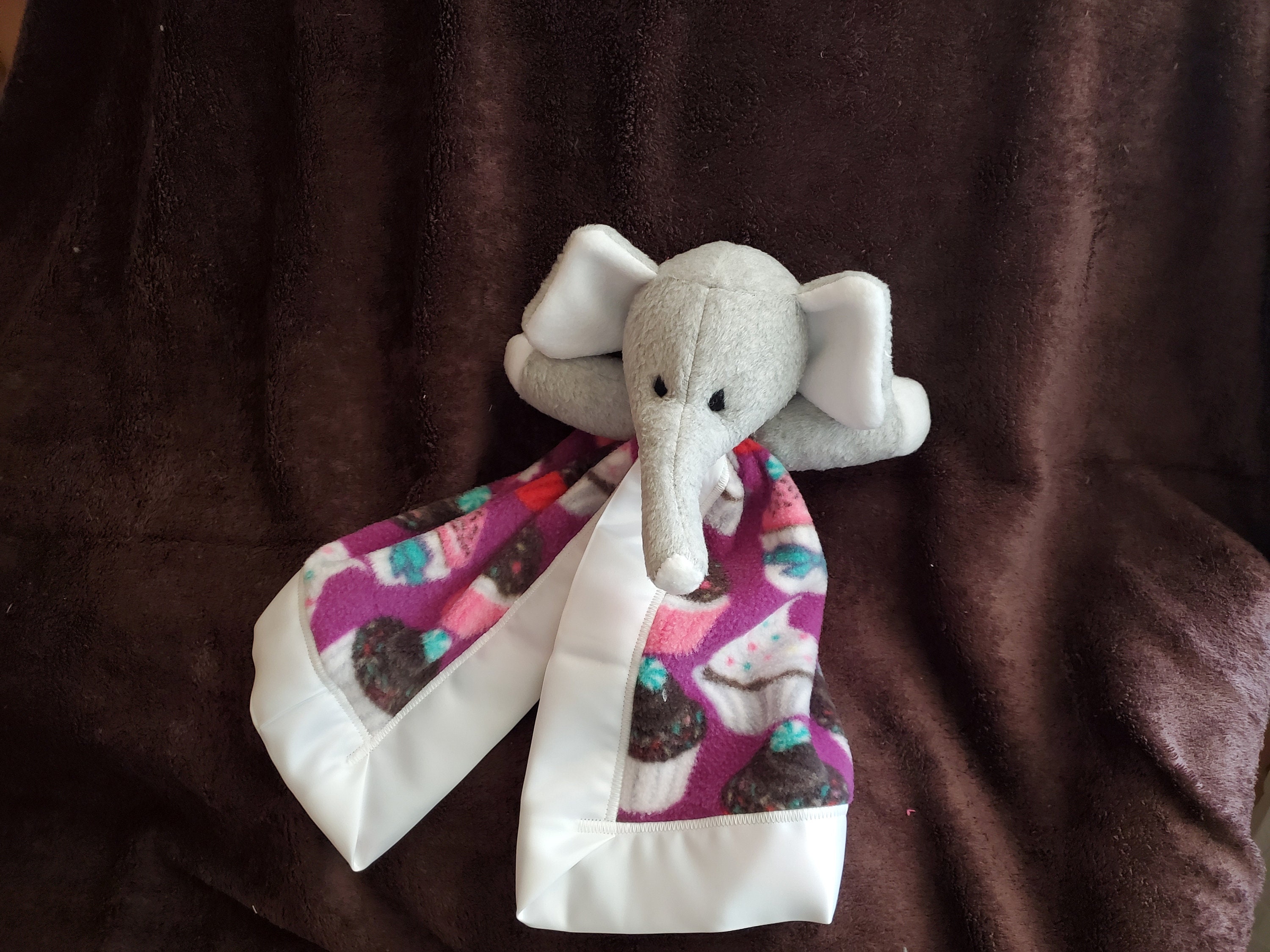 Mini Elephant Blanket Buddy Who is Oh so Cuddly With a Cupcake Design on a Purple Background and