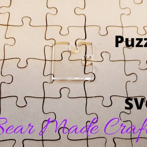 May include: A clear plastic puzzle piece on a brown background with the text "Puzzle SVG Bear Made Crafts" in purple.
