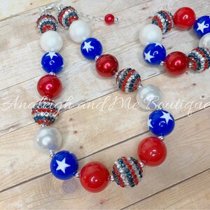 May include: A red, white, and blue beaded necklace and bracelet set with stars and rhinestones. The necklace and bracelet are made of large, chunky beads.