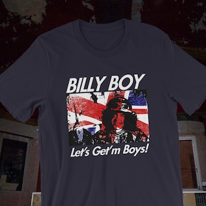 May include: A navy blue t-shirt with a distressed white graphic of a man wearing a helmet and goggles in front of a Union Jack flag. The text "BILLY BOY" and "Let's Get'm Boys!" is printed in white on the shirt.