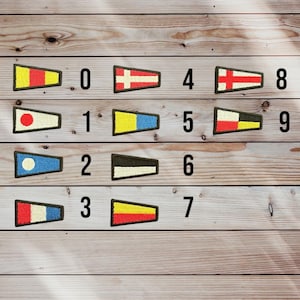 May include: A collection of embroidered nautical signal flags, each with a unique design and number. The flags are in various colors, including red, yellow, blue, and white, and are arranged on a wooden surface.