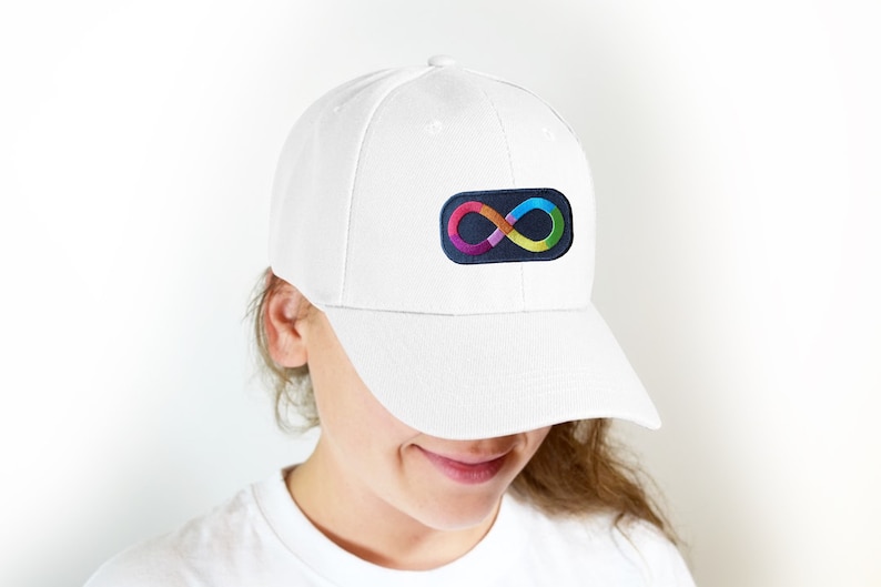Puede incluir: Gorra de b&eacute;isbol blanca con un parche de s&iacute;mbolo de infinito colorido. El parche presenta un s&iacute;mbolo de infinito de color arco&iacute;ris sobre un fondo azul oscuro. La gorra est&aacute; hecha de una tela suave y texturizada y tiene una visera curva.