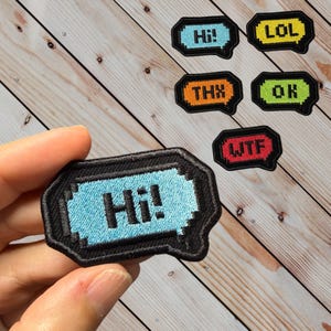 May include: A set of embroidered iron-on patches with various internet slang words, including "Hi!" "LOL", "THX", "OK", "WTF". The patches are black with colorful lettering.