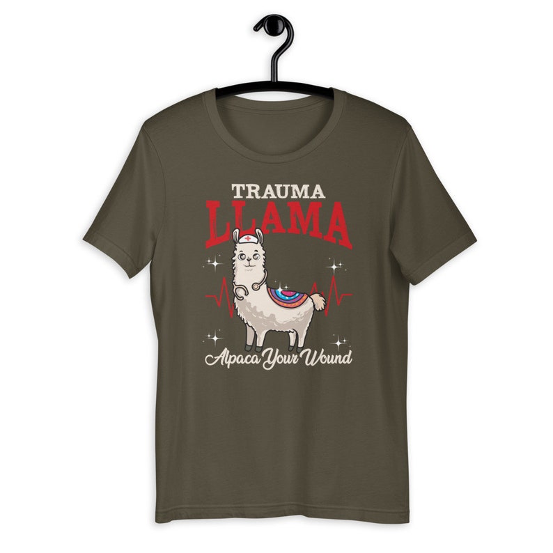 K&ouml;nnte beinhalten: Ein dunkelgr&uuml;nes T-Shirt mit einem Cartoon-Lama, das eine Krankenschwesterm&uuml;tze und ein Stethoskop tr&auml;gt. Der Text "Trauma Llama" befindet sich &uuml;ber dem Lama und "Alpaca Your Wound" unter dem Lama.