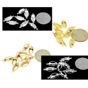 May include: A set of 10 silver, gold, and chrome oval-shaped pendant settings with two loops on each side. The settings are shown next to a US quarter for size comparison.