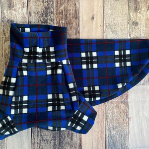 May include: A blue, black, white, and red plaid pet accessory. The item is made of a soft material and is designed to fit around a pet's neck. The plaid pattern features a repeating square design.