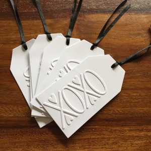 Paquet de 5 étiquettes-cadeaux de Noël/Fêtes en relief. Médaillons oblongs avec motif XOXO. Couleur du ruban au choix. GT12.