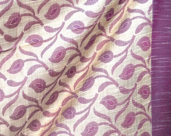 Pode incluir: Um tecido creme com um padrão repetido de formas de folhas roxas. O tecido tem uma borda roxa com uma fina faixa dourada. O texto "Vedad Designs" é visível no canto inferior direito.