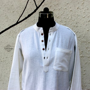 May include: A white long-sleeved shirt with a mandarin collar and a single button closure. The shirt has a small pocket on the left side and is made of a lightweight fabric.
