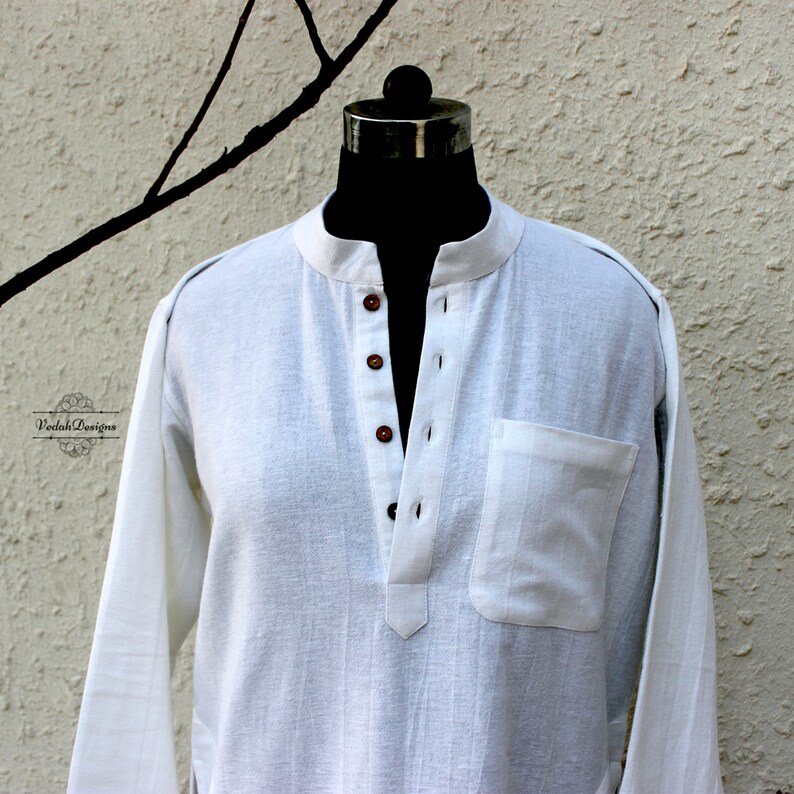 May include: A white long-sleeved shirt with a mandarin collar and a single button closure. The shirt has a small pocket on the left side and is made of a lightweight fabric.