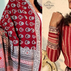 Puede incluir: Textil estampado en rojo y blanco con un patr&oacute;n floral repetido. Se ven las mangas de una blusa estampada en rojo y blanco. La blusa tiene un patr&oacute;n de hojas verticales y est&aacute; adornada con botones dorados.