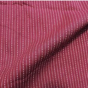 May include: A deep burgundy fabric featuring a pattern of vertical white dashed lines. The material has a visible woven texture and is draped to create soft folds, highlighting the consistent spacing of the white stitch-like markings.