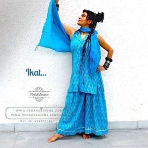 K&ouml;nnte beinhalten: Eine Frau tr&auml;gt ein Oberteil und eine Palazzo-Hose im Ikat-Muster in Blau und Wei&szlig; mit einem passenden blauen Schal. Der Text "Ikat..." ist oben im Bild zu sehen. Der Text "Vedah Designs" ist in der Mitte des Bildes zu sehen. Der Text "www.vedahdesigns.com" und "www.vedahdesigns.etsy.com" ist unten im Bild zu sehen. Der Text "PH: +91-8287770867" ist unten im Bild zu sehen.