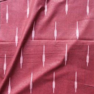 May include: A deep maroon fabric featuring a repeating pattern of vertical, light pink ikat-style dashes. The textile has a visible woven texture with subtle horizontal lines running across the surface, creating a consistent and structured appearance.