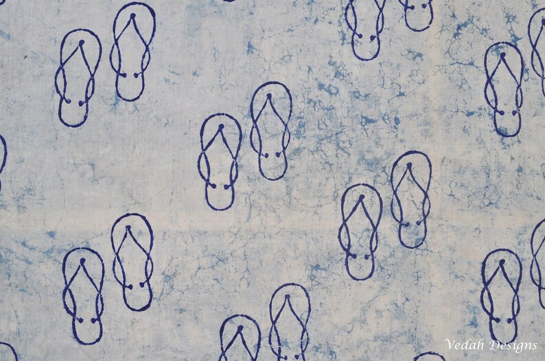 Pode incluir: Um tecido azul claro com um padr&atilde;o repetitivo de chinelos azuis escuros. O design do chinelo &eacute; simples, com uma al&ccedil;a e uma sola. O fundo tem uma apar&ecirc;ncia manchada, com &aacute;reas azuis mais claras e escuras.