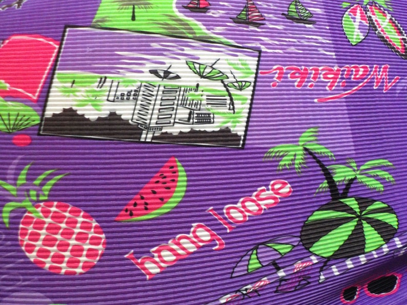 May include: Purple fabric with a tropical print featuring palm trees, watermelons, pineapples, and the text "Hang Loose".