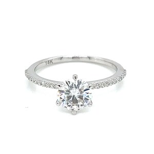 May include: A silver ring with a large round diamond in the centre and smaller diamonds set in a pave setting around the band. The ring is marked "14K" on the inside of the band.