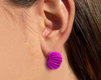 May include: A pair of bright pink, geometrically shaped earrings. The earrings are made of a smooth, shiny material and have a slightly rounded shape.