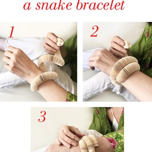 May include: A three-step guide on how to wear a snake bracelet. The bracelet is made of stacked, light-colored, rounded segments. The text "How to wear a snake bracelet" is in gray and red.