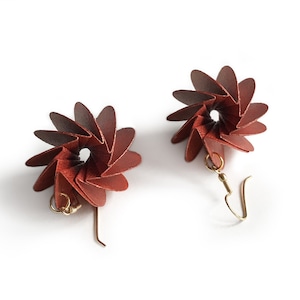 May include: A pair of red origami flower earrings with gold hooks.