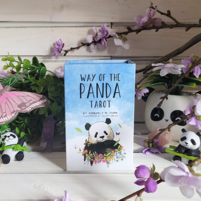 May include: A blue box with the text "Way of the Panda Tarot" on the front. The box features a watercolor illustration of a panda bear surrounded by flowers. The text "By Kimberly M. Tsan Illustrated by Celin Libelle" is printed below the title.