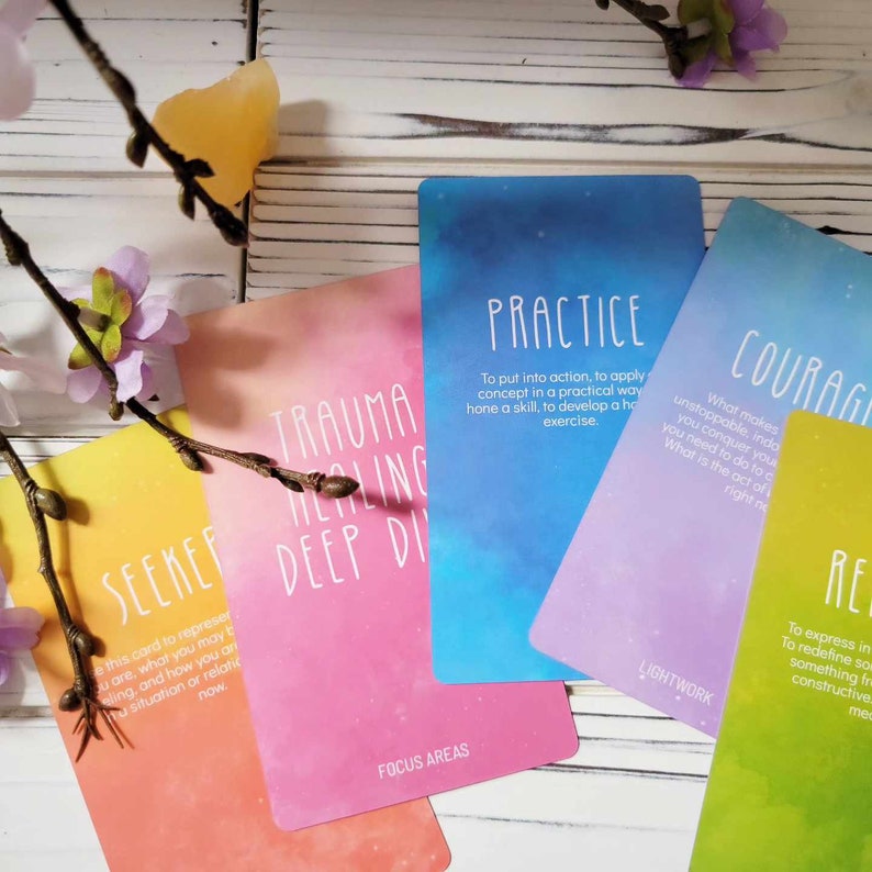 K&ouml;nnte beinhalten: F&uuml;nf farbige Karten mit inspirierenden Botschaften und Aquarellhintergr&uuml;nden. Die Karten sind betitelt mit "Trauma Healing Deep Dive", "Seeker", "Practice", "Courage" und "Redefine".