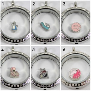 May include: Six silver locket pendants with clear glass fronts and crystal accents. Each locket features a different Alice in Wonderland themed charm, including Alice, a bottle of drink me potion, a cookie that says "eat me", the Cheshire Cat, the Queen of Hearts, and a clock.