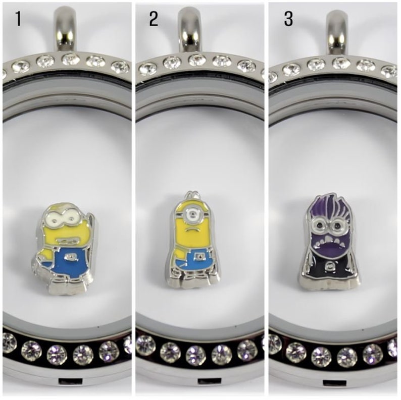 May include: Three silver locket necklaces with clear crystal accents. Each locket contains a different character from the Despicable Me franchise. The first locket contains a yellow minion with blue overalls. The second locket contains a yellow minion with blue overalls. The third locket contains a purple minion with a black suit.