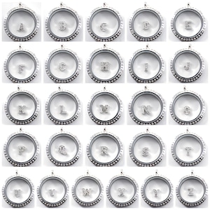 May include: A collection of silver-toned, round lockets, each containing a different letter of the alphabet. The letters are embellished with small, sparkling crystals. The lockets are displayed against a white background.