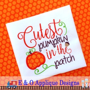 May include: White square fabric with the embroidered phrase "Cutest pumpkin in the patch" in red and brown. A cartoon pumpkin and green vines are also embroidered. The background is orange with white polka dots.