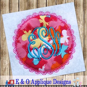 Może przedstawiać: Okrągła aplikacja w kolorze różowym i białym z niebieskim monogramem w środku. Okrąg ma różowy falisty brzeg.