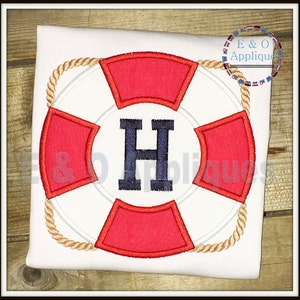 May include: A red and white life preserver with a rope border and the letter H in the center. The life preserver is embroidered on a white t-shirt.