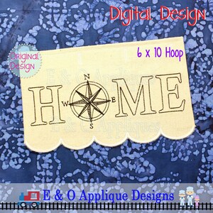 May include: A beige fabric banner with the word "HOME" embroidered in black thread. A compass with a black outline is centered between the "H" and the "O". The banner has a scalloped edge and is designed for a 6x10 inch embroidery hoop.