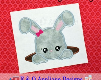 May include: A gray bunny with pink ears and a pink bow is peeking out of a brown hole. The bunny has large black eyes and a small pink nose. The image is on a white background.