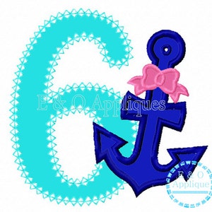 May include: A turquoise blue letter G with a blue anchor and a pink bow. The anchor has a white outline. The letter G is outlined with white triangles.