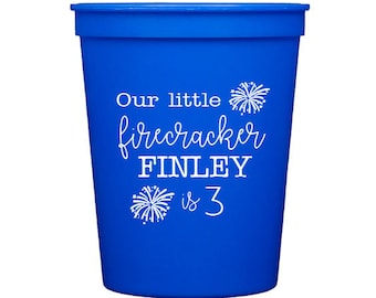 May include: Blue plastic party cup with white text that reads "Our little firecracker FINLEY is 3" with a firework graphic.