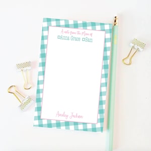 May include: A blue and white gingham notepad with a pink border. The notepad has the text "A note from the Mom of Anna Grace & Sam" at the top and "Ainsley Jackson" at the bottom.