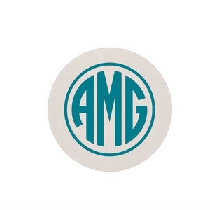 May include: A white round coaster with a teal blue circle containing the letters "AMG" in a monogram style.