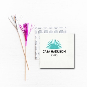 May include: White paper napkin with a teal agave plant design and the text "CASA HARRISON 4905" printed in black.
