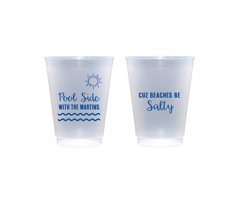 May include: Two clear plastic cups with blue text. The left cup says "Pool Side with the Martins" and has a sun and waves graphic. The right cup says "Cuz Beaches Be Salty".